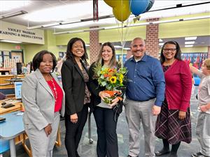 Kelli Glisan surrounded by Dr. Hill and coworkers.